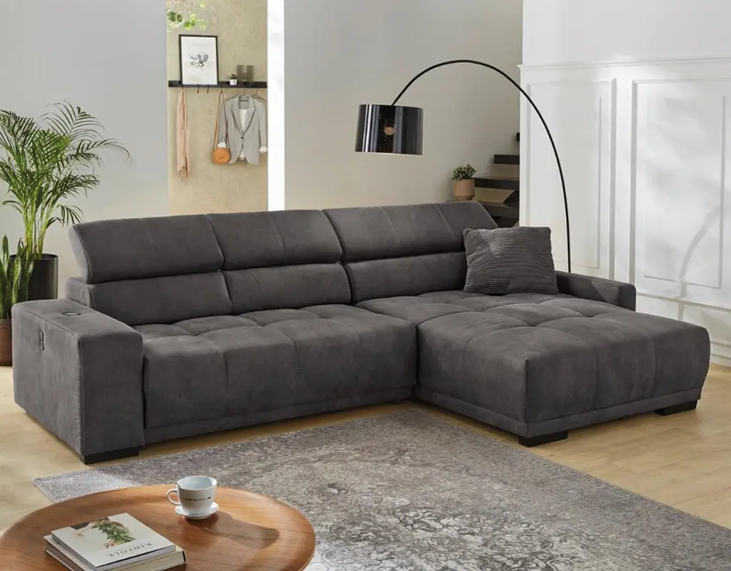 Modernes dunkelgraues Ecksofa mit Relaxfunktion in stilvollem Wohnzimmer mit Holzdetails, großem Teppich und eleganter Bogenlampe. Perfektes Polstermöbel für gemütliche Wohnräume und maximalen Komfort.